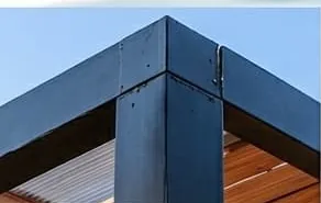 Detalle de la viga metálica de la pérgola contra los listones de madera