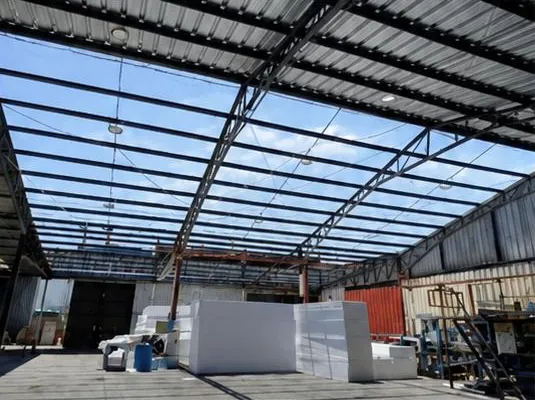 Interior de una bodega con estructura metálica y cubierta translúcida