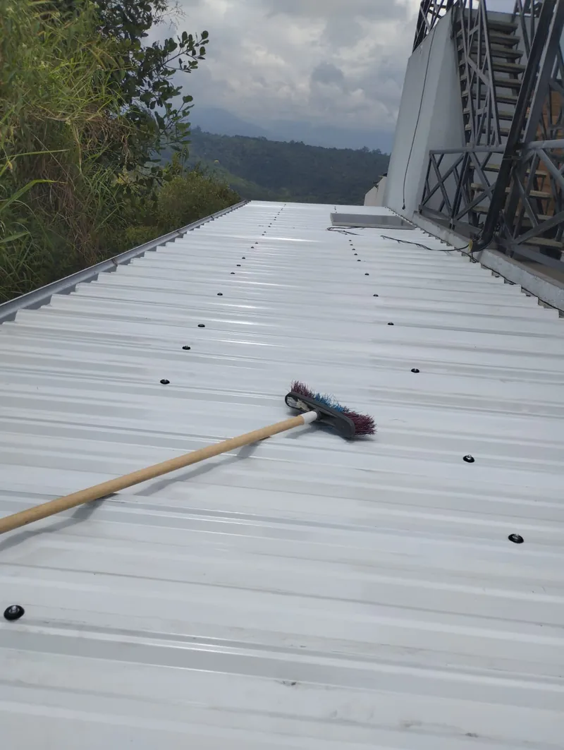 Cubierta de lámina metálica blanca recién instalada sobre una azotea, con una baranda en X al fondo