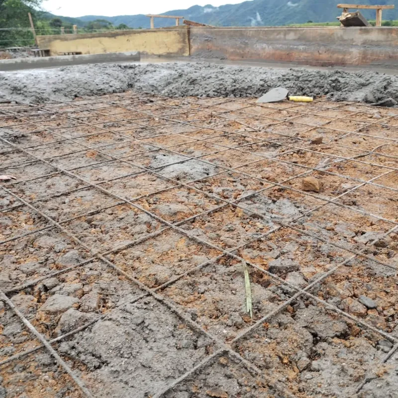Malla de acero de refuerzo sobre terreno preparado para fundir una placa