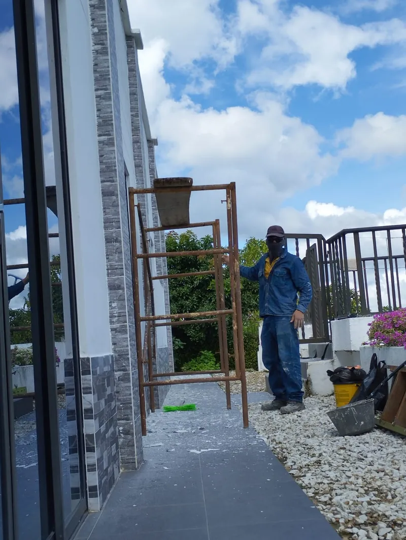 Trabajador junto a un andamio en el andén de la casa durante la obra de la terraza